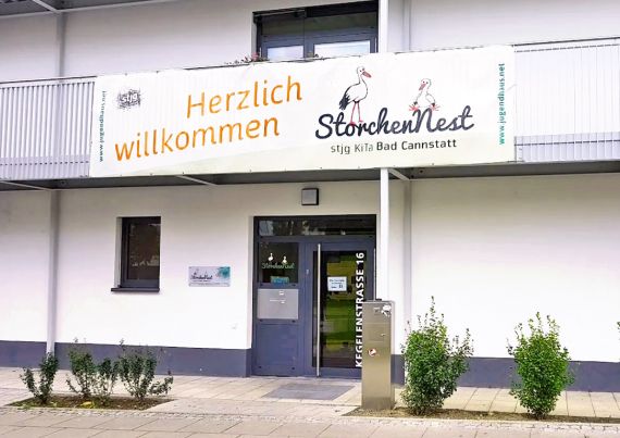 Der Eingangsbereich der Kita Storchennest mit großem Banner über der Eingangstür
